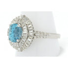 This statement ring has 2 halos of diamonds surround this large oval blue zircon.