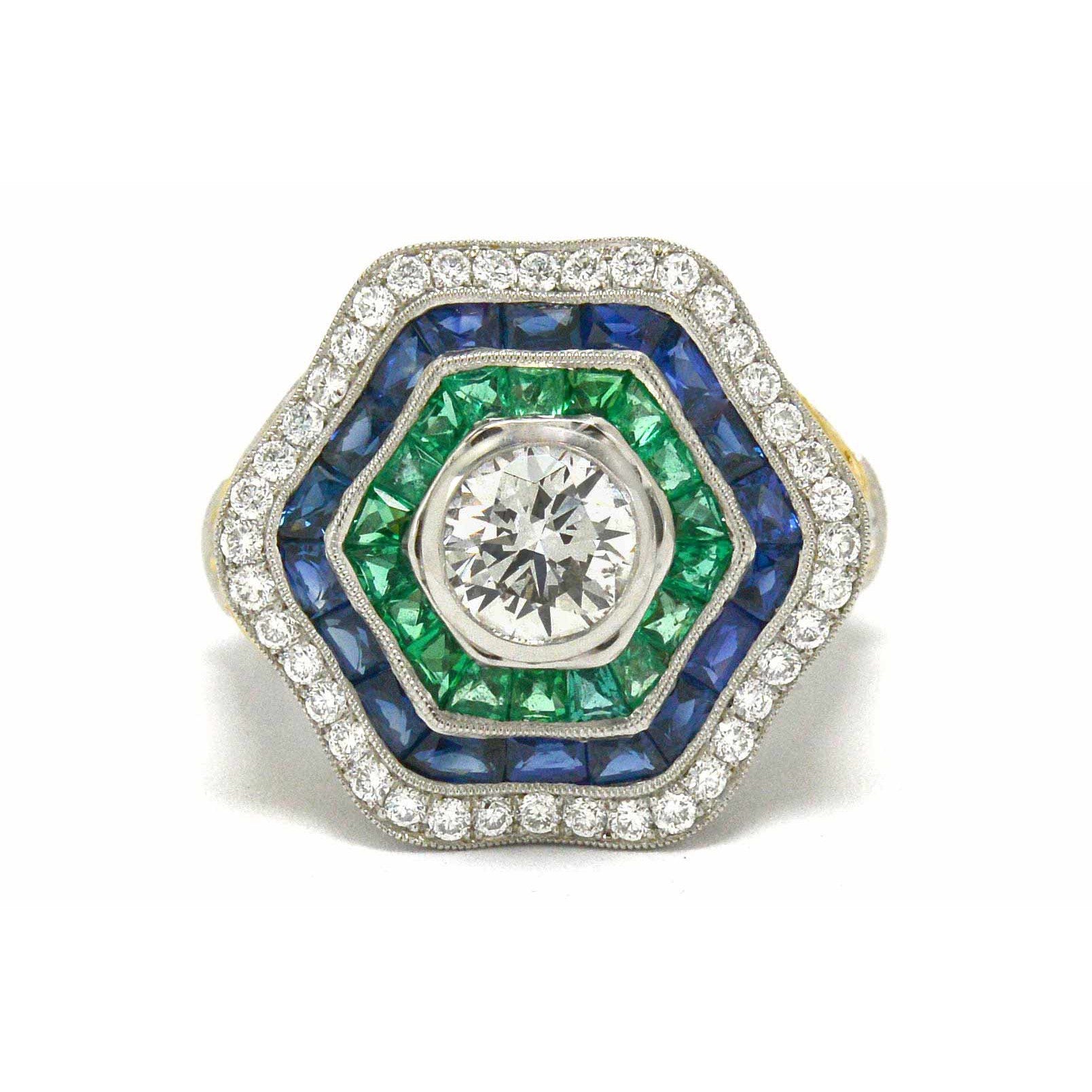 A platinum hexagon ballerina ring with diamonds, emeralds and sapphires.