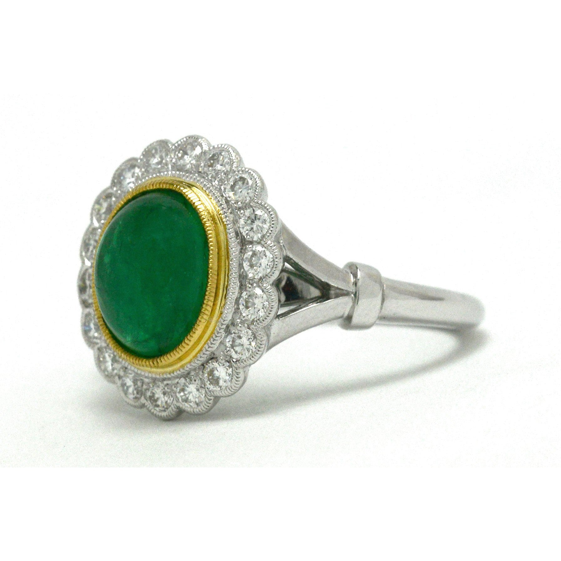 A 2 tone 18k gold bezel set emerald engagement ring.