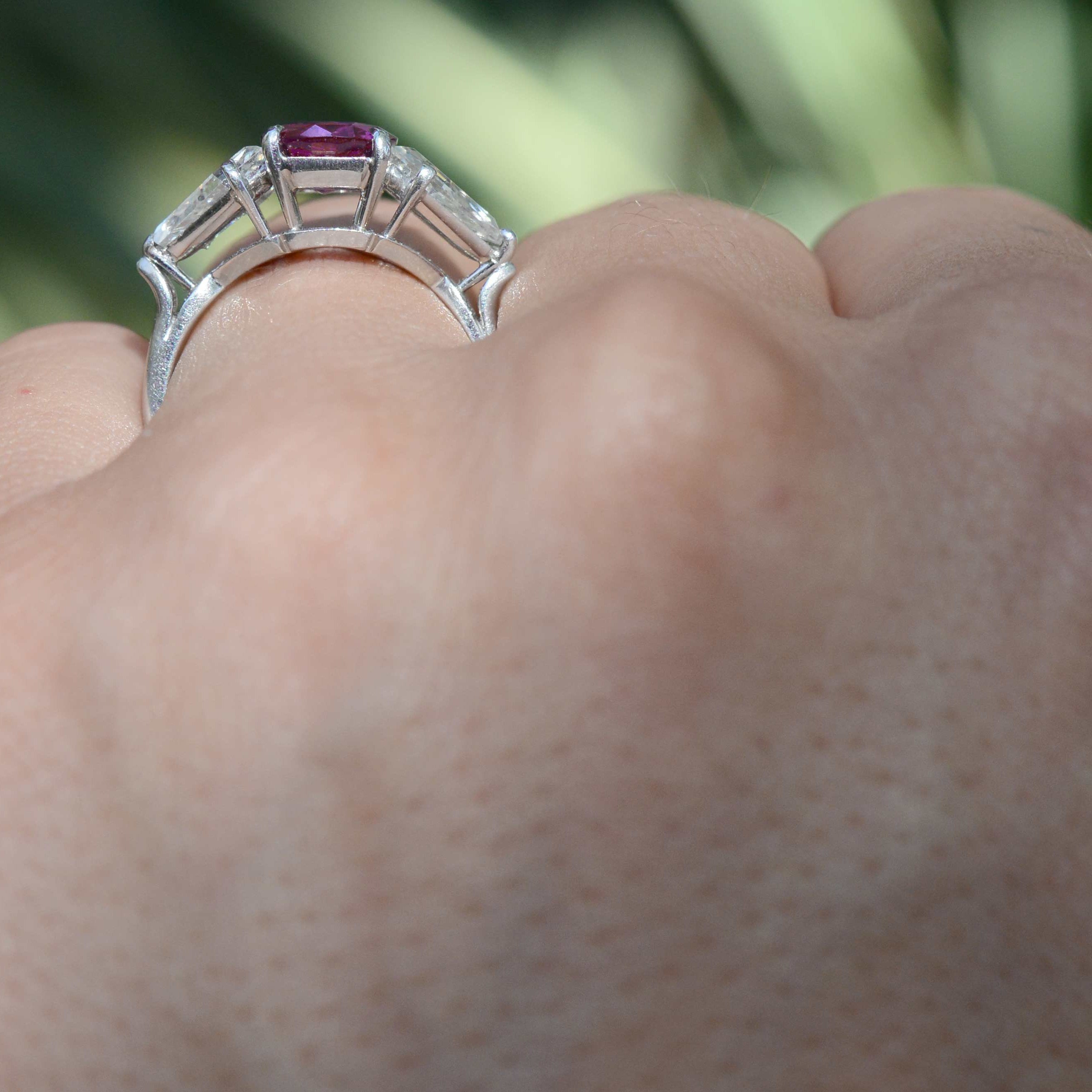 A natural bright pink sapphire set amongst 2 kite cut diamonds in a unique engagment ring.