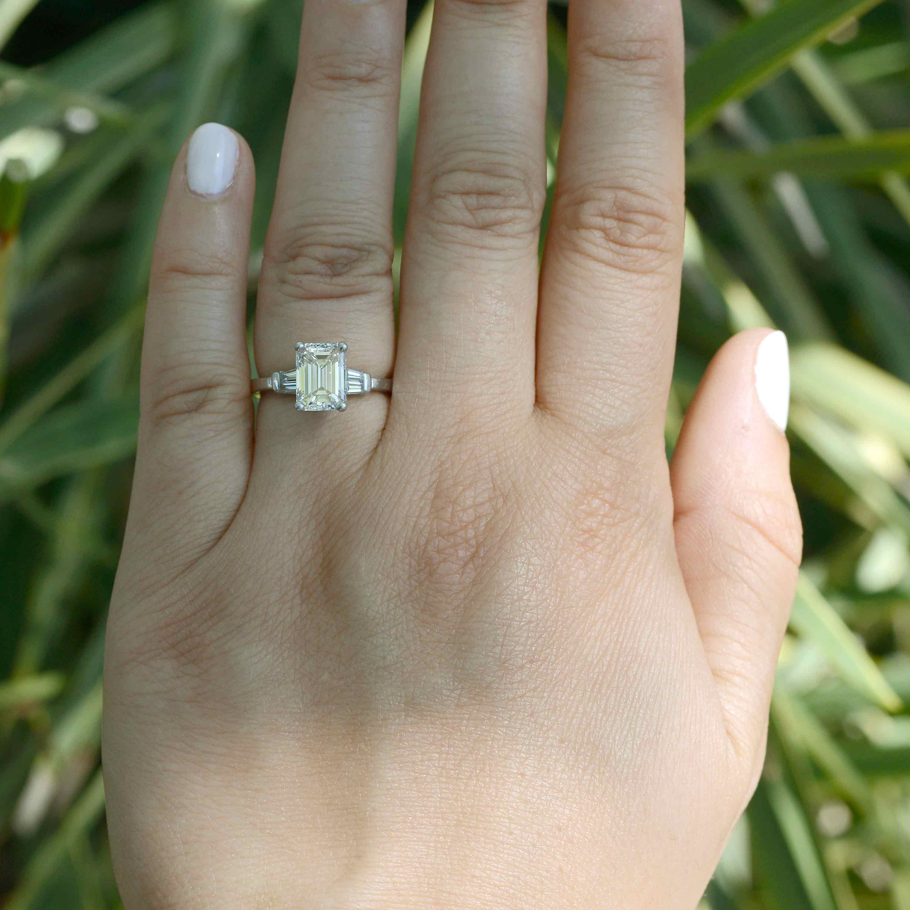 The center two carat emerald-cut diamond has an exquisite brilliance and liveliness.