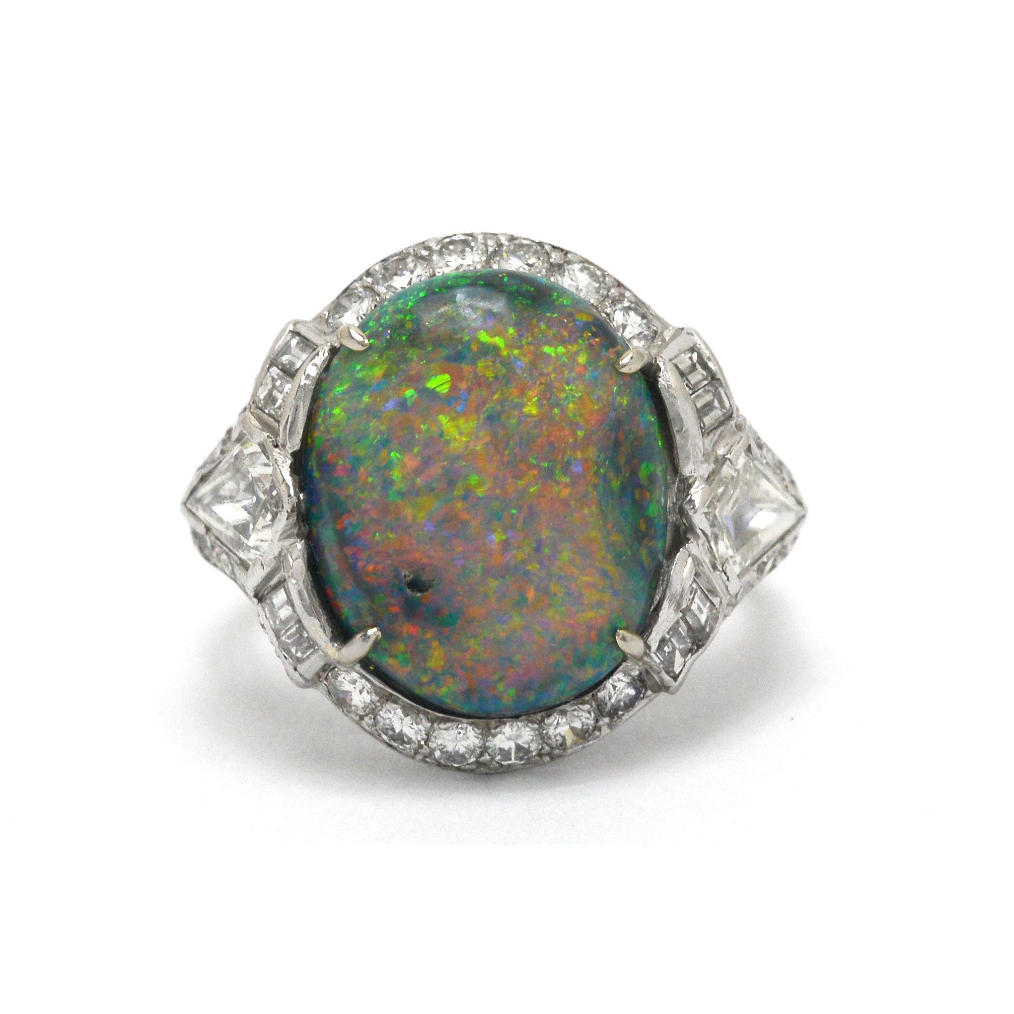 A large black opal set in a diamond halo, Art Deco dome ring.