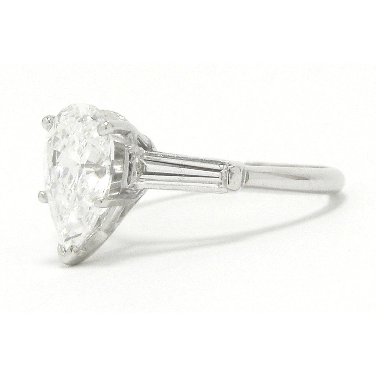 A platinum pear cut diamond solitaire wedding ring with baguette cut accent gems.