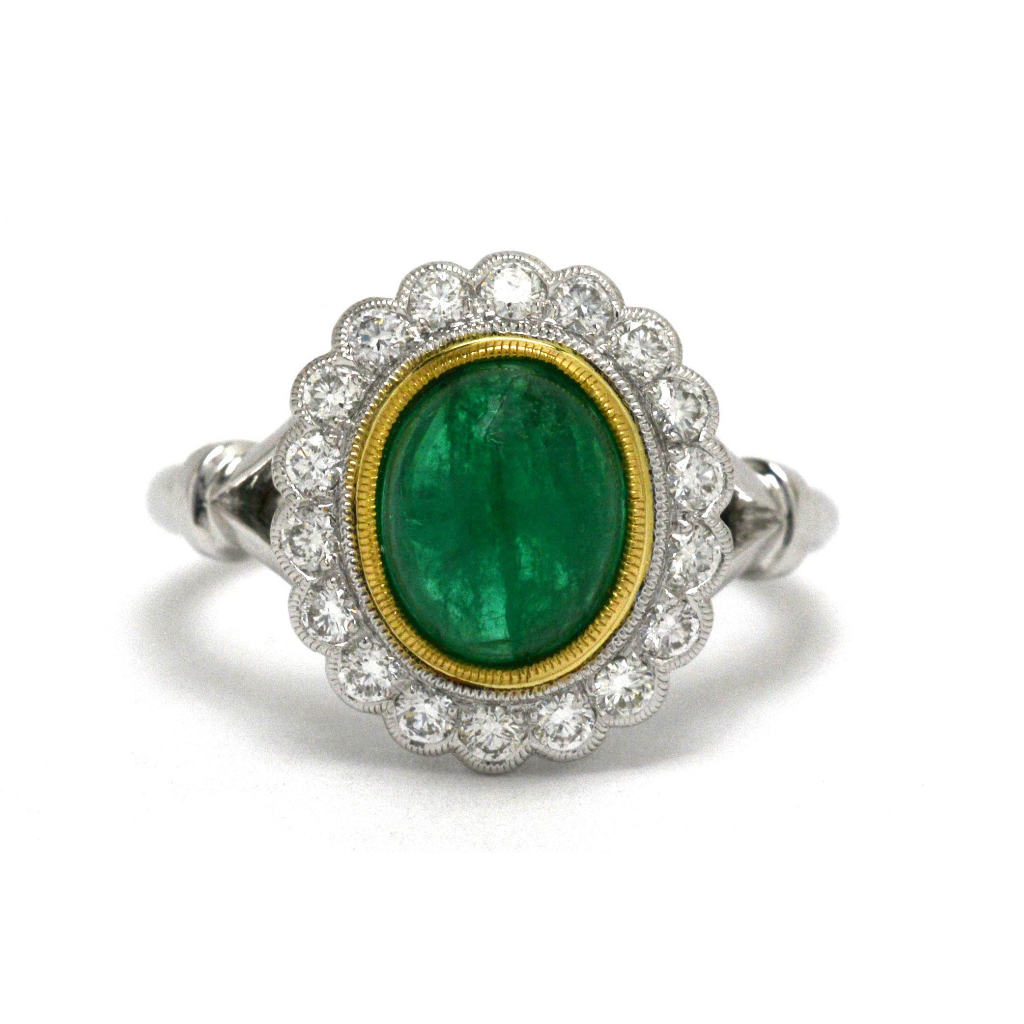 An Edwardian style emerald and diamond halo Princess Diana ring.