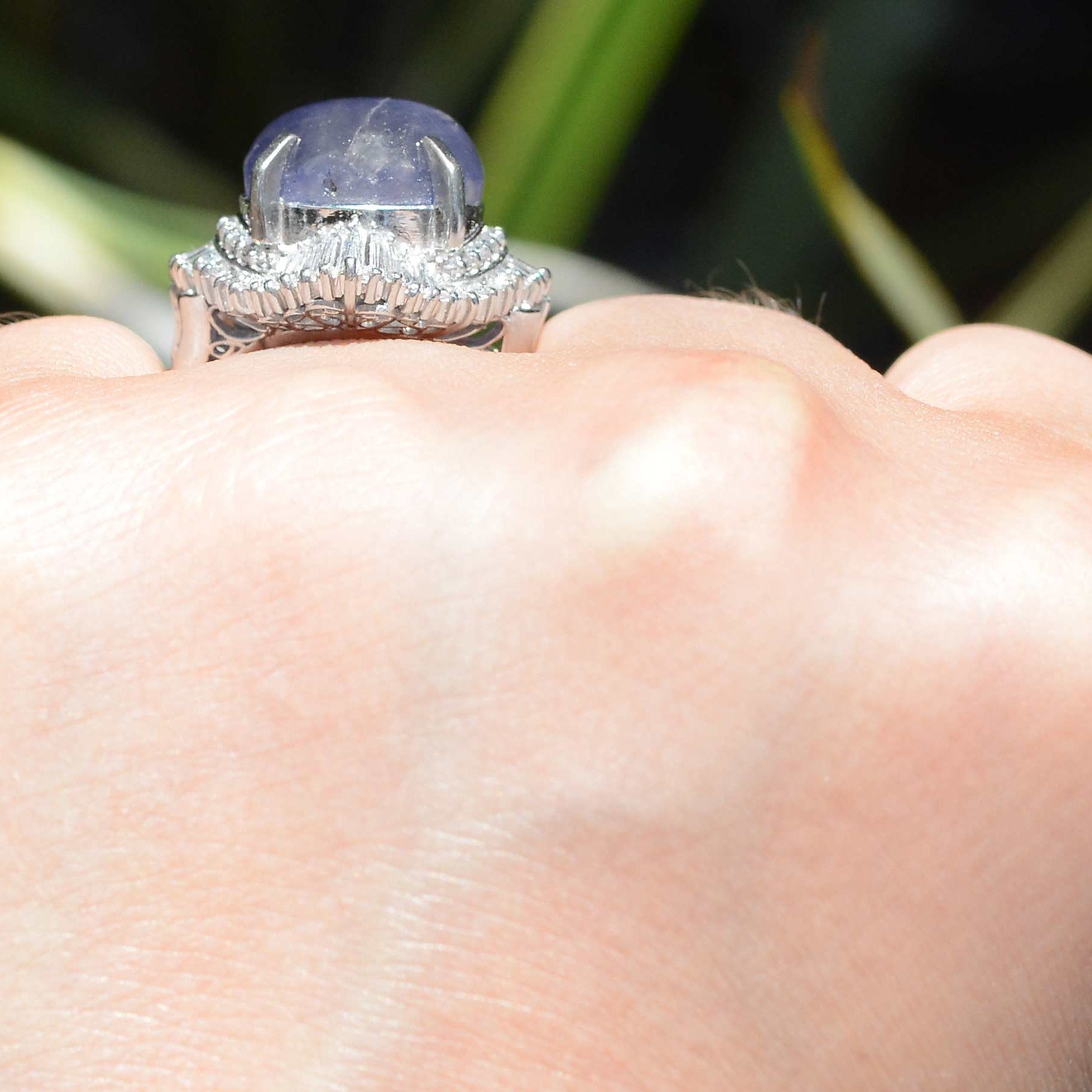 A halo of tapered baguette diamonds line this stunning purple star sapphire dome ring.