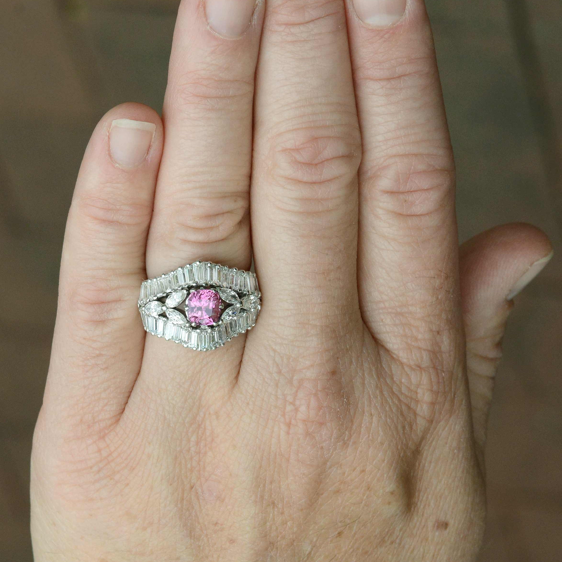 A retro floral platinum engagement ring with flowers to the side. 