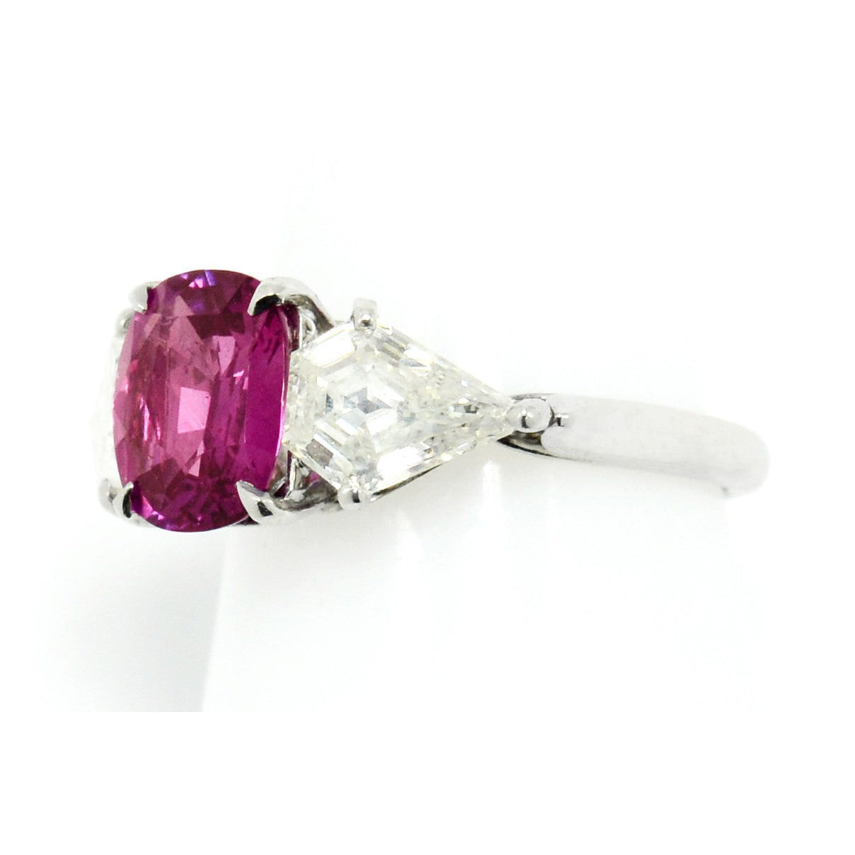 A 2 carat pink sapphire 3 stone platinum engagement ring with diamonds.