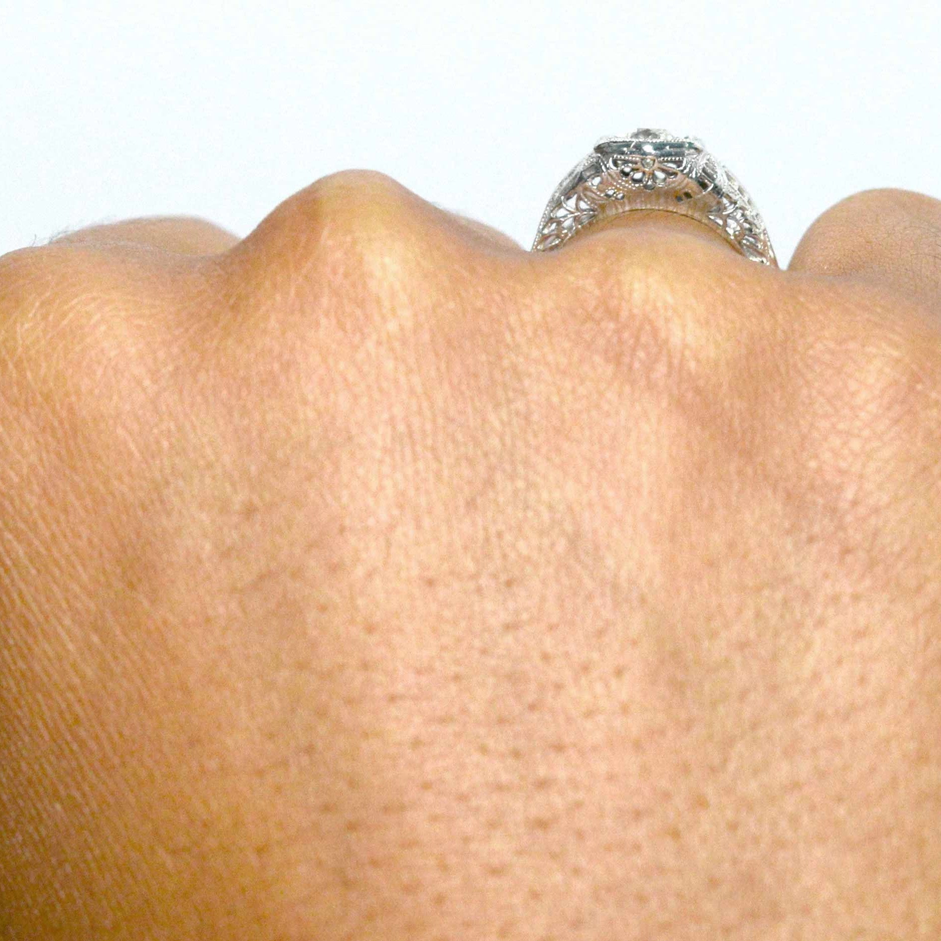 A diamond wedding ring with an 18k white gold filigree shank.