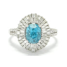 An oval faceted five carat blue zircon statement ring with two halos of diamonds.